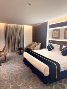 吉赞فندق سنبات بلاتينيوم的酒店客房带一张大床和一把椅子