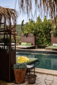 圣埃乌拉利亚Finca Legado Ibiza的游泳池设有两张床和一张桌子