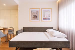 波尔图Catarina Serviced Apartments的一间卧室配有一张床和一张桌子