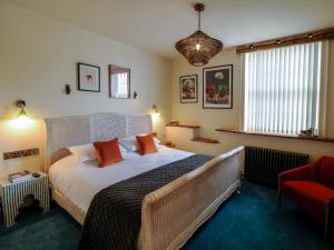 Great Eccleston卡特福德旅馆的一间卧室配有一张大床和一张红色椅子