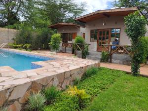 NarokEmirishoi Cottages and Garden Bistro的庭院中带游泳池的房子