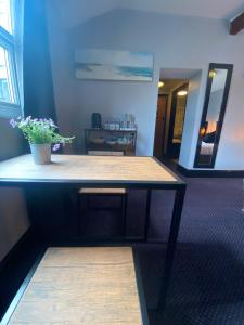 滨海韦斯顿Bay view rooms at Mentone Hotel的一间房间里摆着盆栽植物的桌子