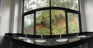 河江LiLa Inn & Motorbike Tours Ha Giang的一间带三个盥洗盆的浴室和一个大窗户