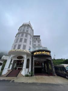 三岛县Tam Đảo Gold Hotel的白色的建筑,前面有标志