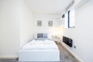 伦敦Modern 1 BR Apartment Near Shoreditch - 10 Min Walk的一间白色卧室,配有床和电视