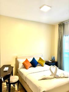 阿吉曼Safari Hotel Apartments的酒店客房配有一张床铺、一张桌子和一张书桌。