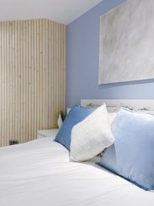 巴克斯顿Garden Apartment - Close to Town Centre - sleeps 6的一张带两个蓝色和白色枕头的床