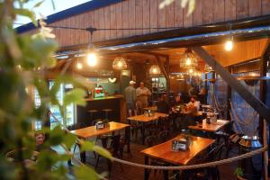 卡尔维亚Big Foot by MANGO Food&Bar的一间设有木桌的餐厅,有人坐在餐厅里