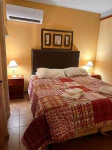 科隆Cabañas Altos de Artalaz的一间卧室配有一张带红毯的床和两盏灯。