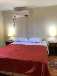 科隆Cabañas Altos de Artalaz的一间卧室配有一张红色的床和两盏灯