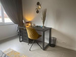 代因泽Appartamento confortevole的窗户客房内的一张带黄椅的桌子