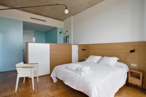 Entrena博德加芬卡洛斯阿迪诺斯酒店的卧室配有一张白色大床和一把椅子