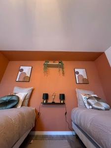 La maison de LYA (lyaroom)的橙色墙壁客房的两张床