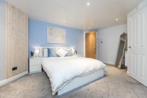 巴克斯顿Garden Apartment - Close to Town Centre - sleeps 6的卧室配有白色的床和蓝色的墙壁