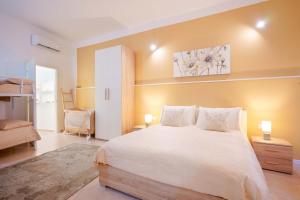 圣安蒂奥科Montellino's Suite Oro的卧室设有一张白色大床和黄色的墙壁
