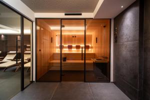 梅拉诺拉德纳酒店的玻璃门通向带桑拿浴室的房间