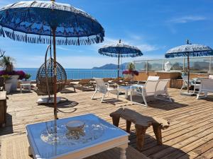 戛纳韦莱斯海滩公寓酒店的一个带桌椅和遮阳伞的甲板