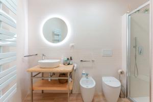 圣安蒂奥科Montellino's Suite Oro的一间带水槽、卫生间和镜子的浴室