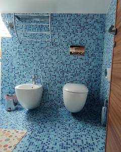 维普里纳克佩尔格拉公寓的蓝色瓷砖浴室设有浴缸和卫生间