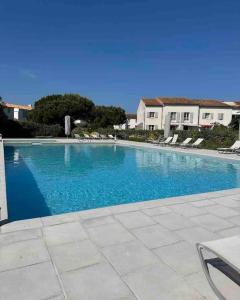 阿尔桑雷IDR-0022 - Maison proche de la plage du Grignon的一座大蓝色游泳池,位于房子前