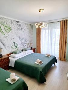 洛夫兰Rooms Sanja, Lovran - Opatija的一间卧室配有两张带毛巾的床