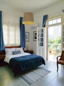 海法伊甸园酒店的一间卧室配有床、蓝色窗帘和窗户