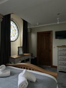 什鲁斯伯里圣尼古拉斯精品酒店 的一间卧室配有一张床、一张书桌和一个窗户。