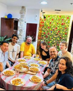 迪拜Dreams beach hostel的一群人坐在桌子旁吃着食物