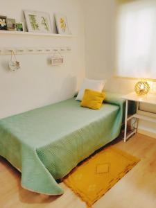 拉斯加比亚斯Salma的一张绿色的床,位于带书桌的房间里