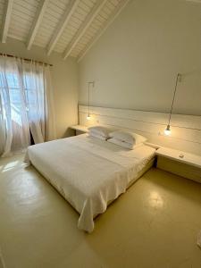 萨摩斯Villa Margarita的卧室设有一张白色大床和一扇窗户。