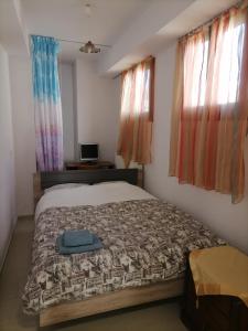 米蒂利尼PERGAMOS APARTMENTS的卧室配有床、电视和窗户。