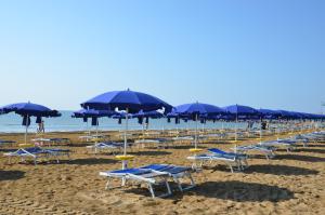 利尼亚诺萨比亚多罗Green Village Eco Resort的海滩上的一排椅子和遮阳伞