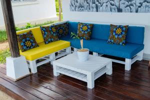 贝岛Long Beach Resort, Nosy Be的蓝色和黄色的沙发以及白色的桌子