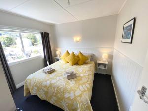 PoharaPohara's Seaside Chalet的一间卧室配有一张带黄色枕头的床和一扇窗户
