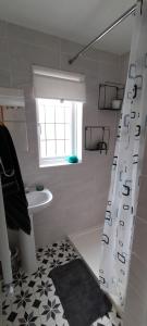 博格诺里吉斯Guest suite 50m from the beach的浴室配有淋浴帘和盥洗盆。