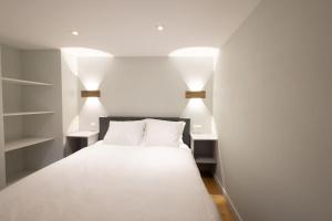 菲斯普Studio-duplex Tower的一间卧室配有白色床和两盏灯