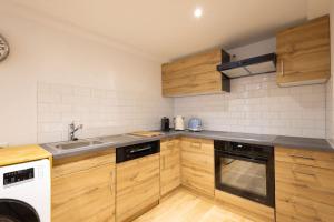 菲斯普Studio-duplex Tower的厨房配有木制橱柜、水槽和洗碗机。