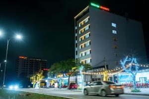 Giáp Vinh YênSAMMY Hotel - Khách sạn SAMMY的夜空在城市街道上,有圣诞灯的建筑