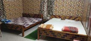 布巴内什瓦尔Luxury stay at Pravuprasad Homestay near Bhubaneswar Airport and Railway Station的墙上的房间里设有两张床