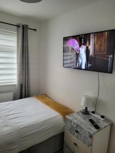 ShevingtonNB's Cozy Nook的一间卧室配有一张床,一张带雨伞的女人的照片