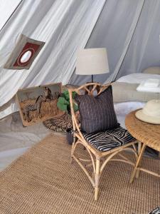 斯塔德Luxury Tent with Restroom and shower, close to the Beach的一间卧室配有带椅子和桌子的帐篷