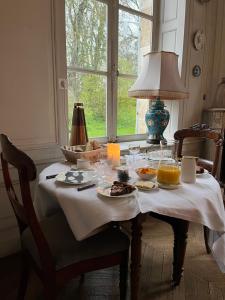 ContayChâteau de Contay Guesthouse - 1753的一张桌子,上面放着食物和饮料