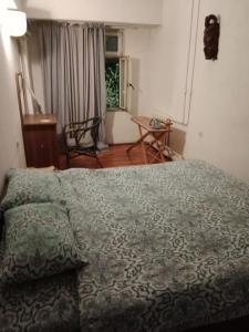 塔什干Apartment Tsentr 5的一间卧室配有一张床、一张桌子和一个窗户。