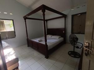 日惹纳尔姆曼特里加温酒店的一间卧室,卧室内配有一张天蓬床