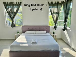 瓜拉丁加奴Garden Homestay Kuala Terengganu的卧室里的一张床,上面有拖鞋