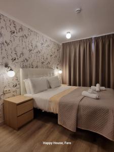 法鲁幸福旅馆的一间卧室设有两张床和华丽的壁纸