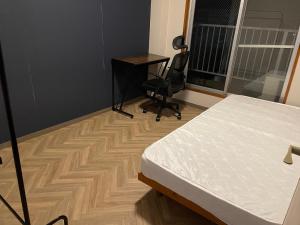 Saiki貸別荘 Reserved VacationStay UND Oita Saiki的一间卧室配有一张床、一张桌子和一把椅子