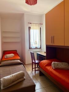 布拉恰诺La Corte del Principe的一间卧室设有两张床、一张桌子和一个窗口。