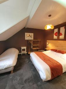 迪纳尔Le petit Montmartre的酒店客房设有两张床和一张桌子。