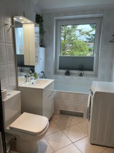 耶莱尼亚古拉Apartament Sweet Home Cieplice SPA的一间带卫生间、水槽和窗户的浴室